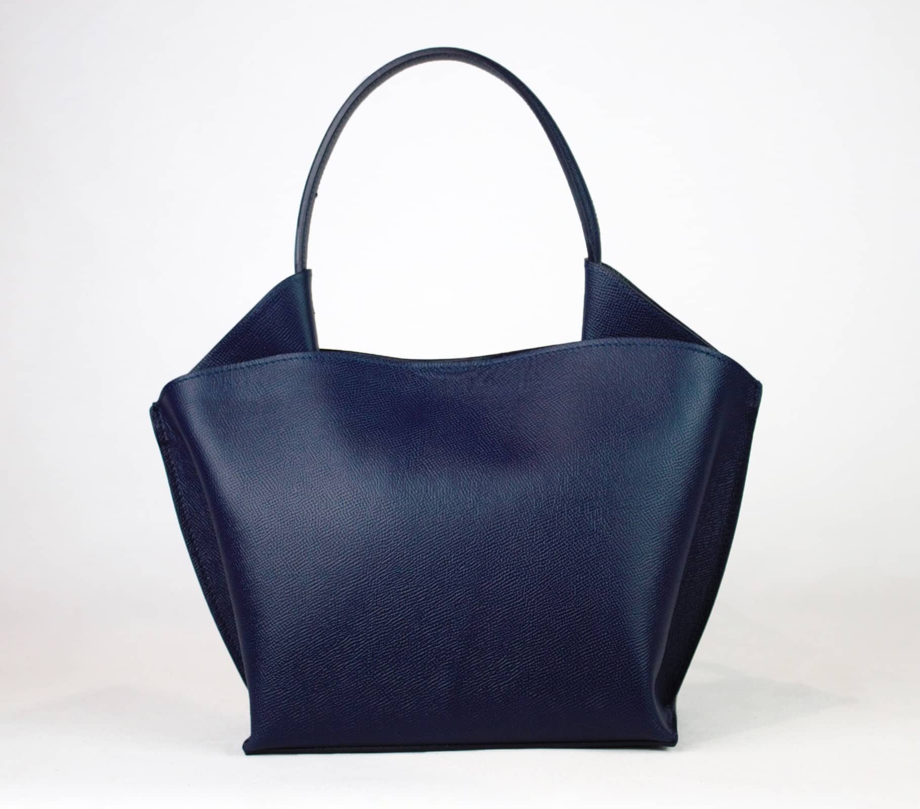 Introducing the RIGID LEATHER HANDBAG by LEATHER COUNTRY, a stylish black handbag with a unique geometric shape, featuring a top handle and a removable shoulder strap. The bag boasts gold-tone hardware, a magnetic closure, and an unlined interior spacious enough for your daily essentials.