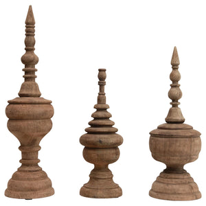 Displayed against a white background are three intricately carved CARVED MANGO WOOD FINIALS (LARGE) by CREATIVE COOP, each featuring unique ornamental designs with a rounded base and a pointed, spire-like top. Perfect as table accents or fireplace mantel decor, the natural finish highlights the wood's grain and texture.