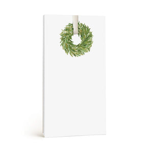 Introducing the WREATH NOTEPAD by E.FRANCES PAPER: This substantial notepad, crafted in the USA, boasts a clean rectangular format with an elegant green wreath illustration adorning the top, set on a simple white background—ideal for all your note-taking requirements.