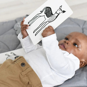 A package of WEE GALLERY - WOODLAND ART CARDS by Wee Gallery is shown. The white box has an illustration of a fox on the cover. One card featuring a drawing of a bear is partially visible outside the box, offering high-contrast pictures designed to boost baby's cognitive development.