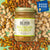 A jar of Big Spoon Roasters Pistachio & Almond Crunch Nut Butter. The jar features a gold lid and a white label with green text. A blue "Good Food Awards" badge is visible on the label, highlighting its use of heirloom mission almonds. The vegan nut butter boasts a crunchy texture.