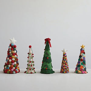 A set of five delightful CREATIVE COOP HANDMADE WOOL FELT TREES WITH POM POMS is displayed in a row. Each tree is uniquely decorated with colorful felt balls, pom poms, stars, and leaves, varying in height and design. The vibrant holiday decorations stand out beautifully against a cream-colored background.