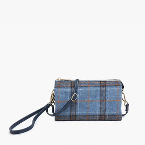 The PLAID CROSSBODY WRISTLET by JEN & CO boasts a blue plaid design on vegan leather, showcasing a grid pattern with brown lines against a plain white background. It features a detachable strap and zipper closure, highlighted by gold-tone hardware on the wristlet strap.