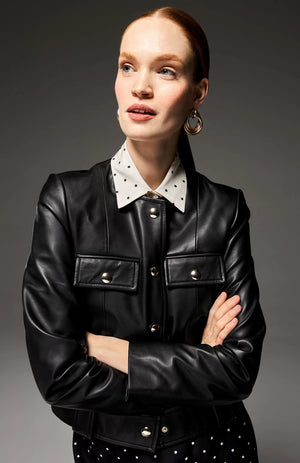 The SEVENTY - SOFT NAPA LEATHER CREWNECK JACKET by SEVENTY is a black leather jacket with a round collar and long sleeves. Made in Italy, it boasts a row of gilded buttons down the front, two buttoned chest pockets, and decorative belt loops at the waist. The design is sleek and minimalist, providing a modern, edgy look.