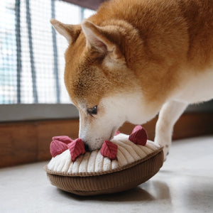 Introducing the LAMBWOLF COLLECTIVE - BERRY PIE DOG TOY, a plush enrichment play object resembling a pie with a quilted crust and topped with fabric strawberries. This round toy features a white filling and has a textured base, designed to imitate a realistic dessert.