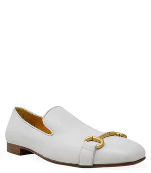 The Madison Maison Square Toe Loafer in gold metallic showcases its handmade craftsmanship and 100% leather composition. This single loafer, characterized by a low wooden heel and square toe, is adorned with a decorative gold buckle on the front. The opulent gold interior lining enhances its luxurious appeal, elegantly displayed in a side profile view against a plain white background.