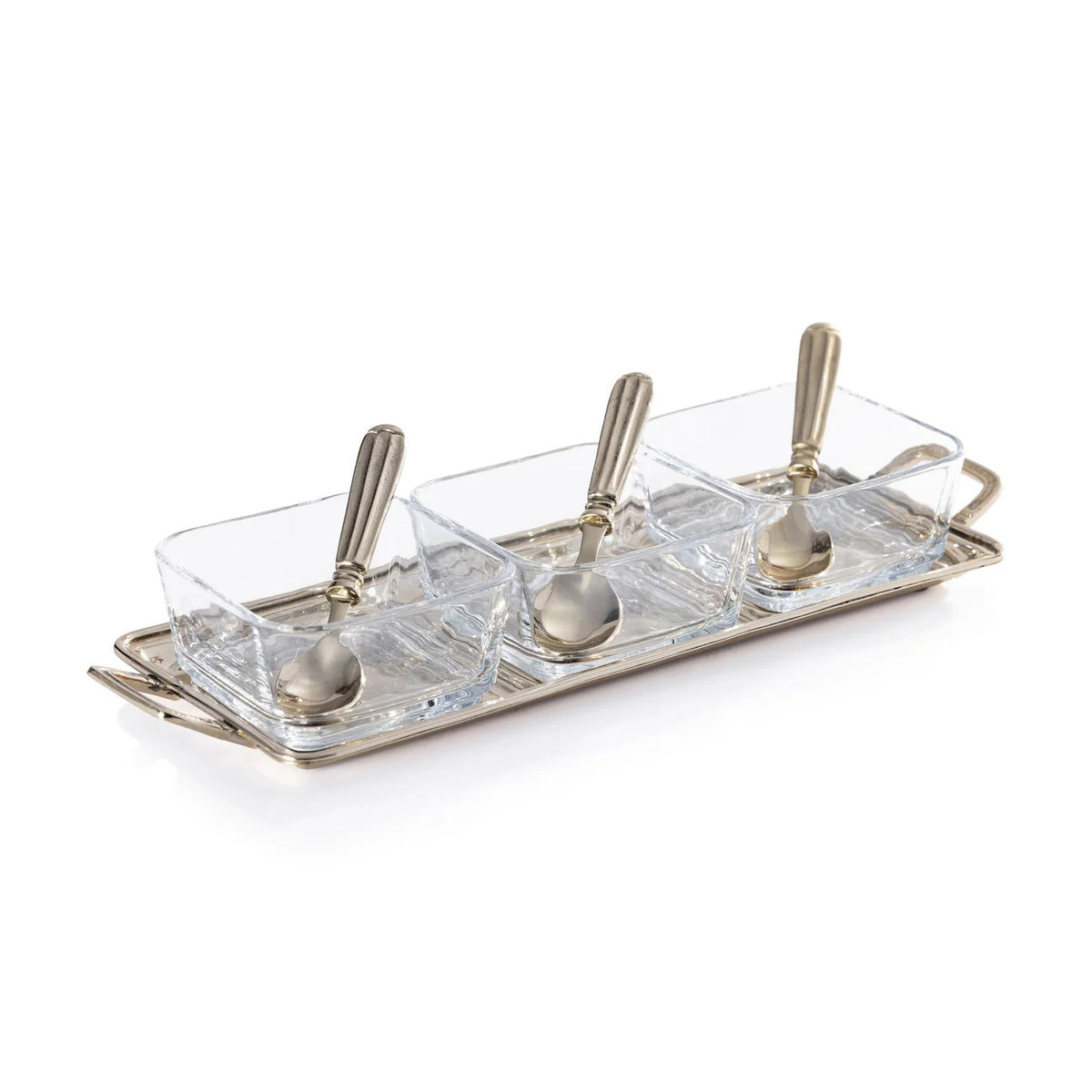 The ROUSSILLON CONDIMENT SET by ZODAX features three clear glass bowls with brass spoons, displayed on a rectangular gold metal tray with handles against a white background.