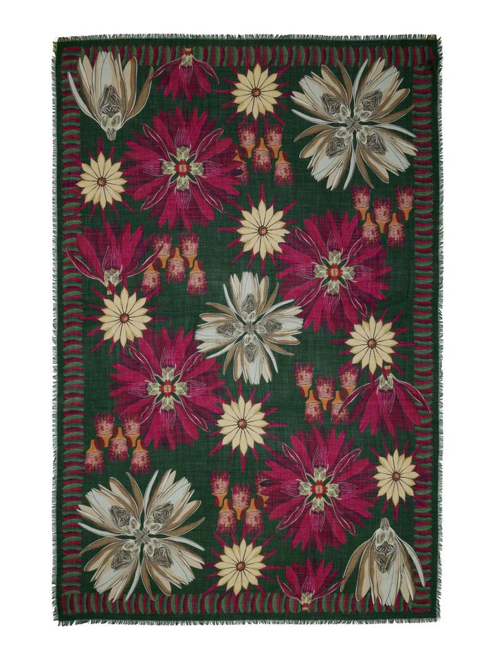 The FRANCO FERRARI - NYMPHAEA WOOL SCARF by FRANCO FERRARI is a long, rectangular scarf crafted in Italy. It features a green background adorned with large red, white, and beige Nymphaea print flowers and leaves. The edges have a slightly fringed finish and are bordered with horizontal red stripes that complement the floral design.