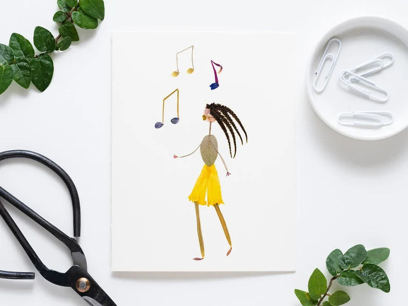 In this delightful greeting card from Petal People Press, a whimsical character with a vibrant yellow petal skirt and leafy body dances gracefully. Above its grass-like limbs float three colorful music notes, creating a harmonious scene on a simple white background.