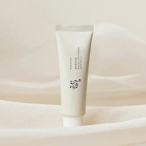 A white, cylindrical tube of BEAUTY OF JOSEON RELIEF SUN RICE AND PROBIOTICS from KOSMIC KBEAUTY SKINCARE stands upright against a plain background. The tube features East Asian characters and English text indicating product details, with a white screw cap attached at the bottom.