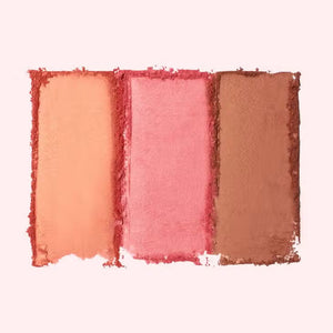 Two makeup palettes, each a JASON WU - BLUSH TRIO from JASON WU BEAUTY, are displayed with three glowing colors. The left blush palette features orange, peach, and pink tones, while the right includes pink, mauve, and rose shades. Swatches of the colors are blended below each corresponding palette.