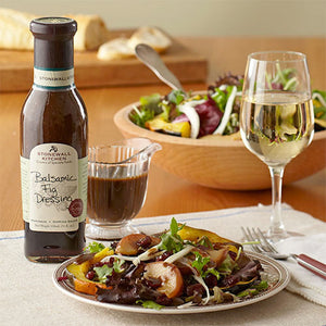 A bottle of STONEWALL KITCHEN-BALSAMIC FIG DRESSING features the product name on a dark bottle with a green label. This delicious gluten-free and non-GMO salad dressing comes in an 11 fl. oz (330 ml) size.