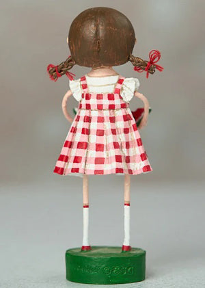 The ESC AND COMPANY - SWEET CAROLINA FIGURINE by ESC AND COMPANY, INC is a charming 6" poly resin figure. It features a girl with brown pigtails in a red-and-white checkered dress, standing on a green base, with her back turned and white socks accented by red stripes.