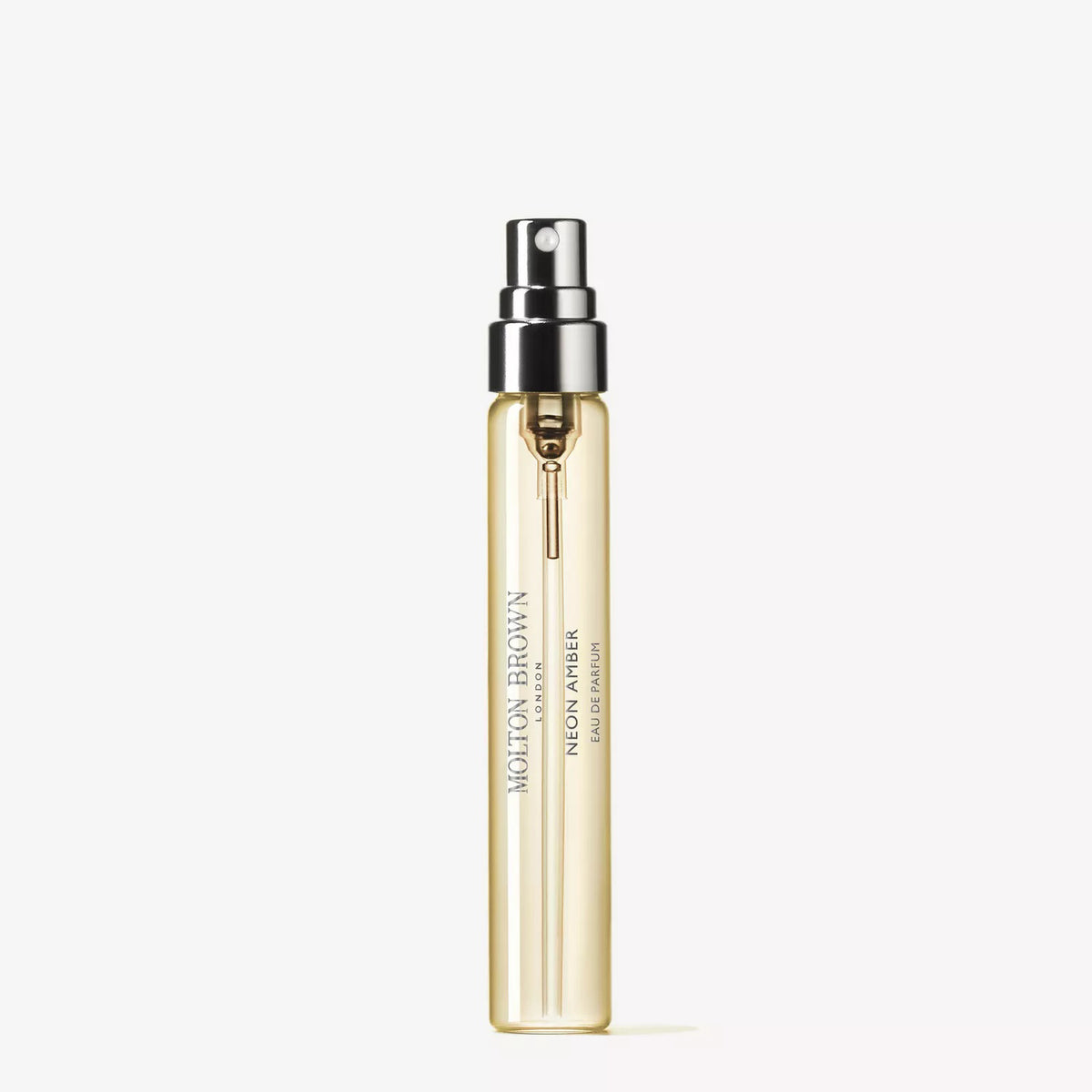 A clear spray bottle containing light yellow liquid, labeled “MOLTON BROWN - NEON AMBER TRAVEL EAU DE PARFUM 0.25FLOZ,” stands upright against a white background, evoking its luxurious amber scent.