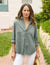 The FRANK & EILEEN - EILEEN RELAXED BUTTON UP SHIRT IN FAMOUS DENIM THYME is a light green, long-sleeved button-up shirt with a single chest pocket. The sleeves are rolled up to the elbows, and the fabric has a slightly crinkled texture. Featuring Eileen's relaxed fit, this shirt includes bust-flattering button placement, a high-low hem, and a collar without a visible tag.