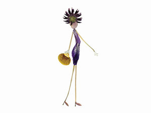 Introducing the CARD CHIC by PETAL PEOPLE PRESS: a whimsical figure crafted from natural materials. This fashionista is adorned in a purple dress with a floral hat made through pressed flower art and holds a small yellow purse. With her long, slender legs, she elegantly poses against a white background.