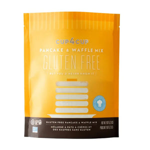 The product displayed is a bag of CUP4CUP GLUTEN FREE PANCAKE & WAFFLE MIX from the brand Cup4Cup. The packaging features a yellow background with white and blue text, emphasizing that it creates delicious gluten-free pancakes and waffles. The bag also proudly states "But you never know it" and includes a certification logo confirming its gluten-free status. The net weight is 907 grams / 2 pounds.