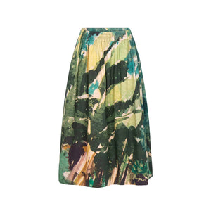 The JUJU CIRCLE SKIRT by TALKING WALLS is an A-line midi-skirt adorned with a striking black and white abstract pattern. It showcases high-end tailoring, featuring a high waist, an elastic waistband, and a pleated design that provides a flowing and voluminous appearance. The bold print includes diverse brush strokes and shapes.