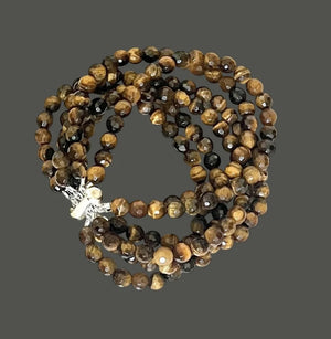 The ANN LIGHTFOOT - TIGER EYE 6 STRAND CUFF BRACELET features polished brown and golden tiger eye beads and a stainless steel clasp, showcased against a white background.