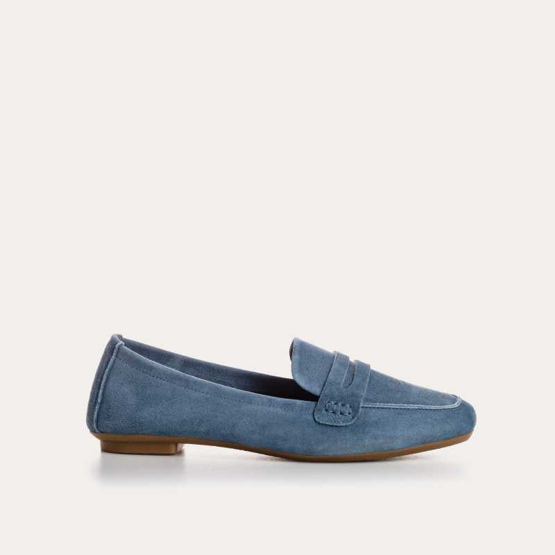 The REQINS - HEMA suede loafer in Blue Jean features a classic silhouette, minimalist design, penny strap, and brown soles, shown against a plain white background.