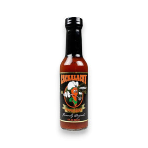 A bottle of CACKALACKY - JACK PEPPER SAUCE GOLD is shown. The label features a cartoon rooster wearing sunglasses and a chef's hat, holding a chile pepper. The bottle contains 5 fluid ounces (150 mL) of this spicy complement, proudly brought to you by the CACKALACKY brand.