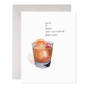 This OLD FASHIONED BIRTHDAY CARD by E.FRANCES PAPER is a white greeting card that showcases a handcrafted watercolor illustration of golden rings. The card features the brand name "E. Frances," along with a barcode and whale silhouette, and it proudly carries the Made in USA label. It comes with a gray envelope.