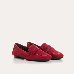A close-up of the REQINS HEMA suede loafer in Cerise, featuring stitching details and a classic penny strap design, set against a light background.