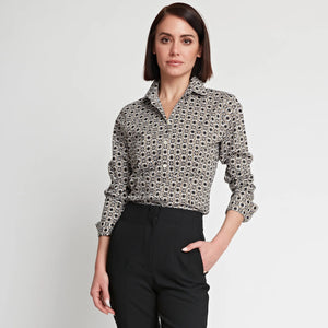 A person with short brown hair is wearing the HINSON WU - DIANE LONG SLEEVE FITTED SHIRT, showcasing tile-inspired prints, along with black pants. They are standing against a plain white background, looking slightly to the side with one hand in their pocket. The fitted style of the shirt from HINSON WU adds to their sharp appearance.