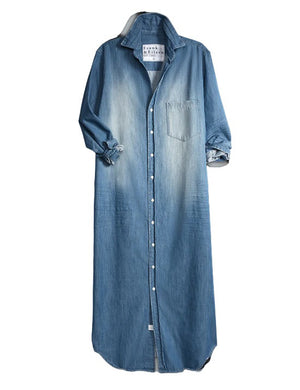 The FRANK & EILEEN Rory Maxi Shirtdress in Famous Denim is a full-length button-up dress featuring a collar, rolled-up sleeves to mid-length, and a single chest pocket. Its sleek, minimalist design embodies that California chic look against a plain white textured background.