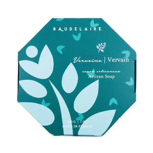 A hexagonal teal-colored box labeled "BAUDELAIRE" at the top. The text reads "Verveine/Vervain savon artisanal - Artisan Soap." Infused with shea butter and boasting a vervain scent, the design includes light blue abstract shapes resembling flowers and leaves. The bottom text indicates 200 g / 7 oz, Made in France. This product, known as the BAUDELAIRE - VERVAIN 7OZ BOXED BATH BAR, is offered by the brand BAUDELAIRE.

