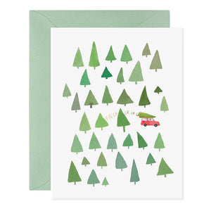 The FA LA LA LA LA TREES HOLIDAY CARD from E.FRANCES PAPER is a handcrafted watercolor greeting card featuring green trees and a small red car, with the phrase "Fa la la la la" among the foliage. Made in the USA, this festive Christmas card comes with a light green envelope, making it perfect for spreading holiday cheer.