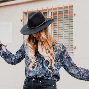 The BILLIE FEDORA HAT by WYETH is a tan wool felt fedora with a leather trim, showcasing a pinched crown and mid brim, beautifully displayed against a plain white background.