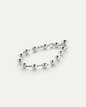 The JENNY BIRD - CELESTE BRACELET from JENNYBIRD highlights a stunning arrangement of polished, round silver beads linked together by short connectors. Its high-polish finish and adjustable design add to the appeal, featuring a modern clasp complemented by an extra dangling bead near the closure for enhanced elegance.