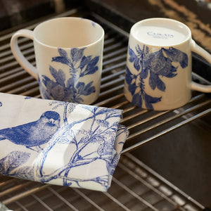 The CASKATA Arbor Birds Kitchen Towels in Blue are a set of two 100% cotton white tea towels featuring a vintage-style design of birds on branches, with detailed artwork infused with botanical whimsy for a classic, elegant feel.