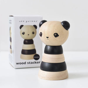 A white packaging box is labeled at the top with "WEE GALLERY" and at the bottom with "PANDA WOOD STACKER." The box features an image of a wooden stacker toy resembling a panda, consisting of alternating black and natural wood rings, designed to enhance fine motor skills through creative play.