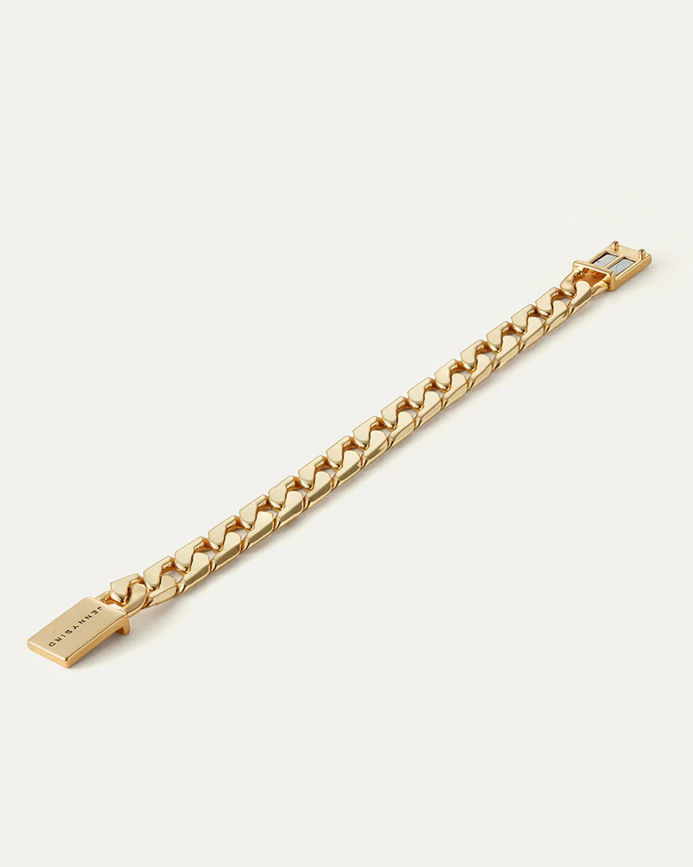 The JENNY BIRD - WALTER BRACELET is an exquisite piece, featuring high polish gold. Its flat curb chain links are tightly connected and complete with a rectangular clasp engraved with text, beautifully showcased on a simple light background.