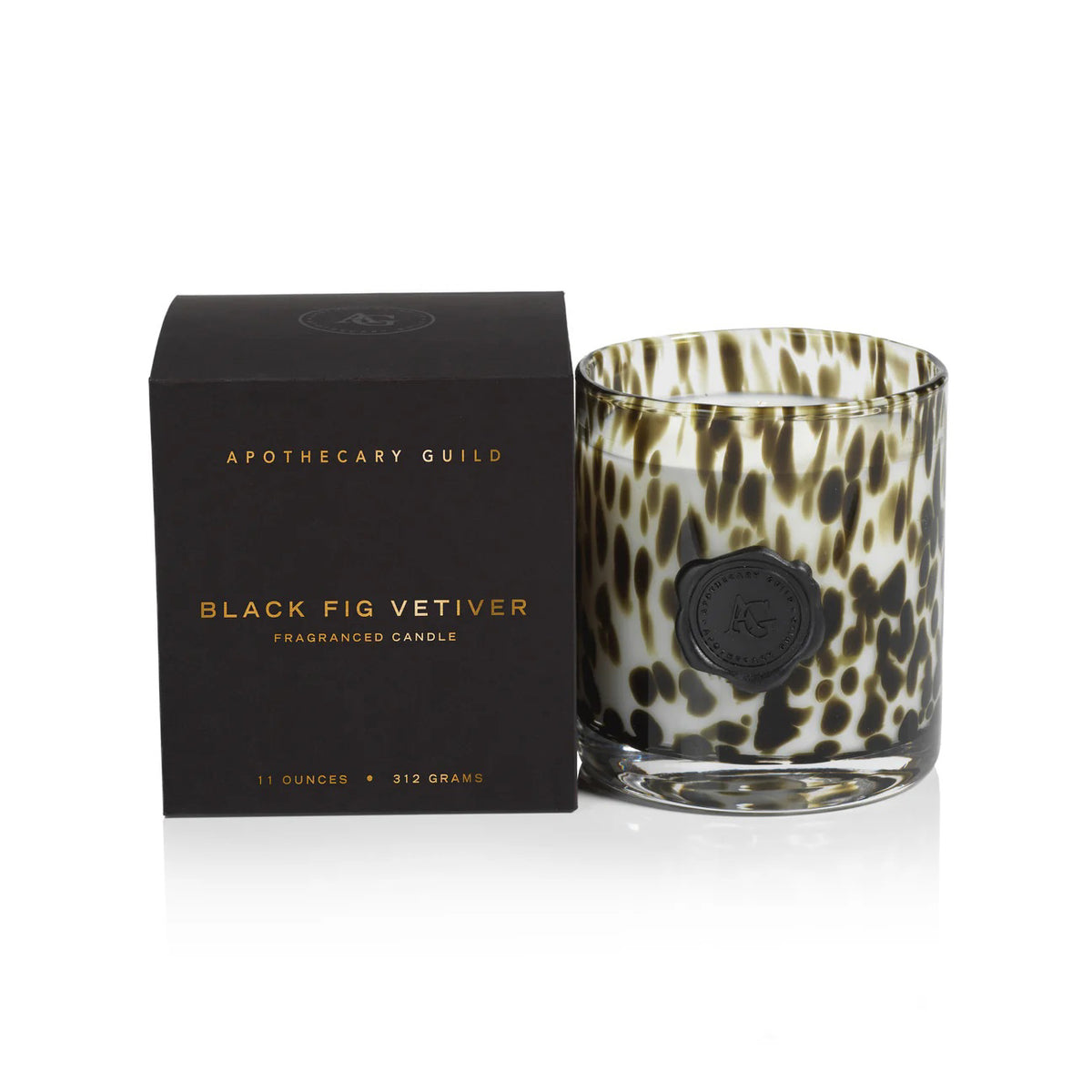 An opal glass candle holder with a black and brown animal print sits beside a black box labeled &quot;Zodax Apothecary Guild Opal Glass Candle - Black Fig,&quot; noted for its luxurious aroma and long-lasting burn.