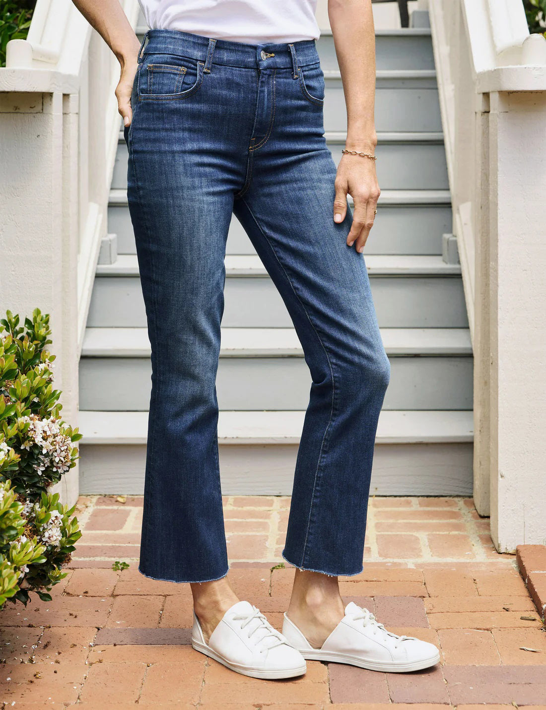 A pair of FRANK &amp; EILEEN - Killian Crop Flare Jeans is displayed flat against a textured white background. Made from soft denim with power stretch, they feature a classic five-pocket design, belt loops, and a button and zip closure. The high-rise legs are slightly flared, offering a clean, modern appearance.