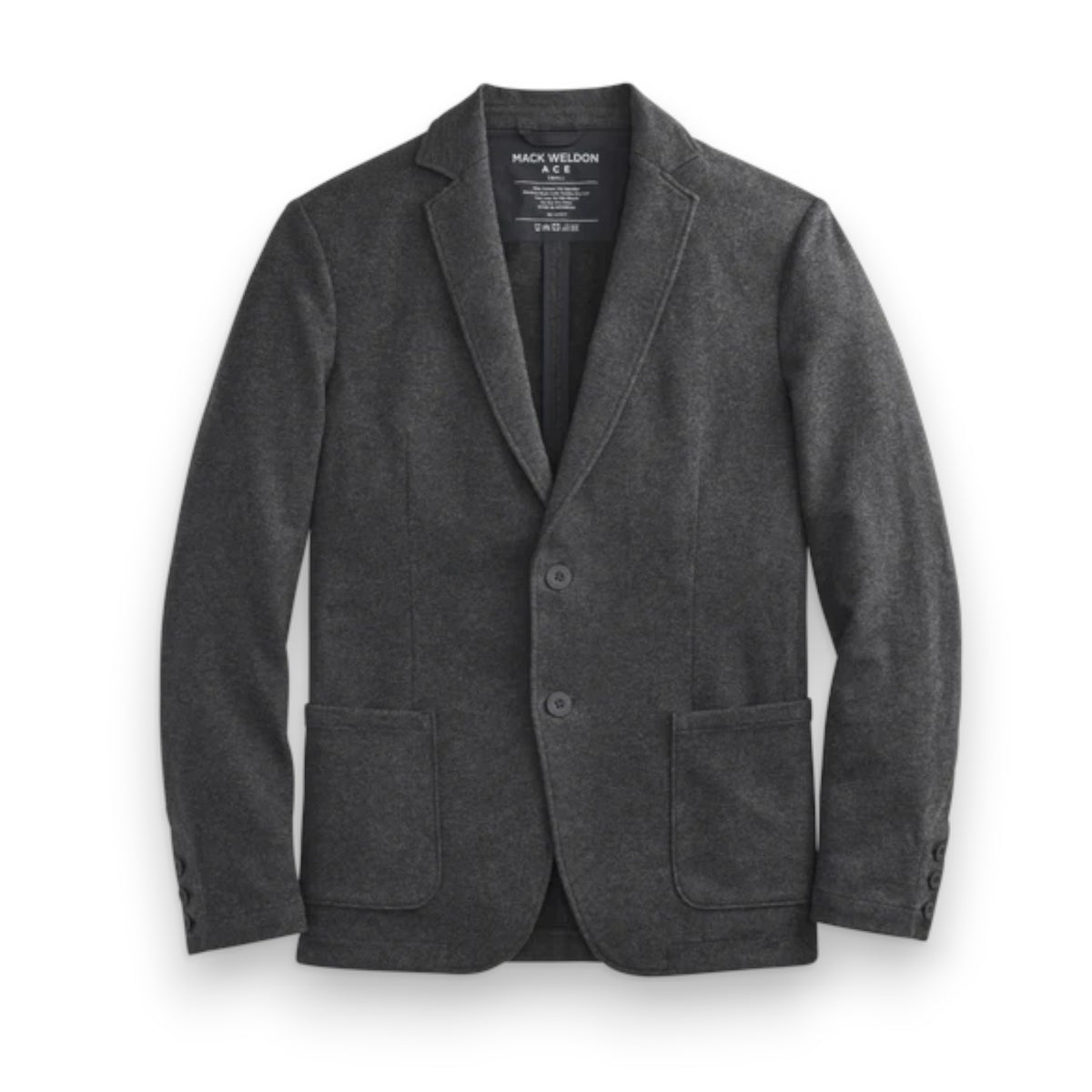 A man fastens the MACK WELDON Ace Blazer in Charcoal Heather over a gray hoodie, white tee, and dark jeans, paired with white sneakers with beige soles. He stands against a plain background, looking slightly to the side.
