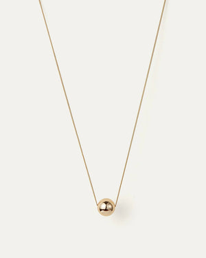 The JENNY BIRD - AURORA PENDANT NECKLACE by JENNYBIRD showcases a delicate chain with a luminous sphere pendant made from high-polish gold, displayed against a plain white background.