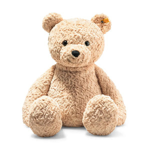 The STEIFF XL JIMMY TEDDY BEAR features a cuddly light brown coat and sits upright against a white background. Its black button eyes, black nose, and small yellow tag in its left ear make it an unforgettable gift to cherish forever.