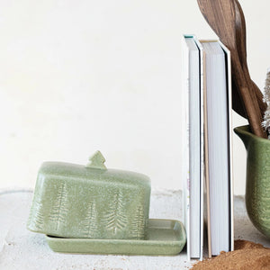 The DEBOSSED STONEWARE BUTTER DISH by CREATIVE COOP is a green stoneware butter dish that includes a lid adorned with embossed tree designs and features a small tree-shaped handle. It is expertly crafted from debossed stoneware and finished with a matte reactive glaze.