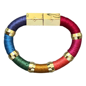 Introducing the HOLST + LEE - COLORBLOCK BRACELET by HOLST & LEE: a circular, multicolored accessory featuring sections of black, beige, and brown materials. This stunning bracelet is embellished with gold rings and a rectangular gold-plated magnetic clasp, seamlessly combining metallic elements with soft textured segments crafted from pearl cotton thread.