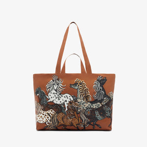 The INOUI EDITIONS MAXI WESTERN SHOPPER BAG from INOUI is a large brown tote with long handles, adorned with an artistic print of various multicolored horses in motion. Crafted from recycled polyester, it features shades of black, white, grey, and brown. This eco-friendly bag boasts a smooth, polished finish and is lightweight for easy carrying.