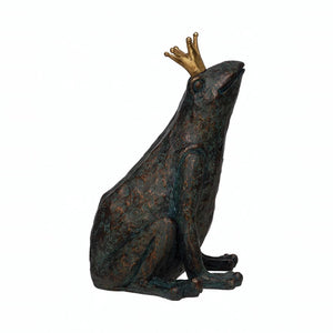 The CREATIVE COOP RESIN FROG WITH GOLD CROWN is a decorative sculpture in bronze patina finish, sitting upright with a gold crown, textured surface, and slightly weathered appearance as it looks upward.