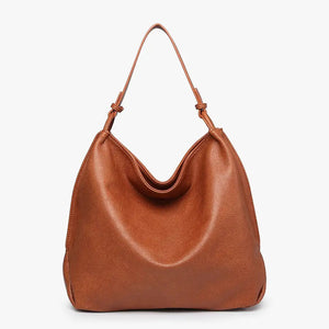 The JEN & CO RUSTIC TOTE is crafted from brown vegan leather and features a relaxed, slouchy shape. Its simple and elegant design includes a single strap attached at both sides, along with an inner compartment for added functionality, all set against a plain light background.