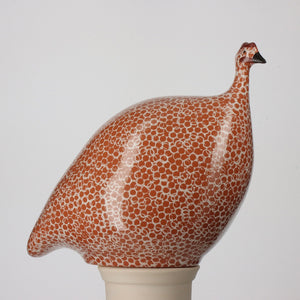 A visual comparison of three LES CERAMIQUES DE LUSSAN French Guinea hens (grand modèle, moyen modèle, petit modèle et modèle qui picore) in Terracotta Red with White Spots and a handmade pottery mug. The ceramic birds are outlined with measurements: 24 cm for the largest, 20 cm for the middle, and 17 cm for the smallest. The mug is 8.50 cm tall.