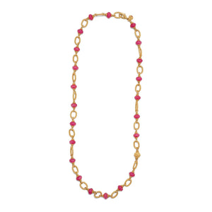 The CAPUCINE DE WULF - BERRY & BEAD NECKLACE by CAPUCINE DE WULF is a versatile piece of jewelry featuring an intricate design with multiple small, oval-shaped semi-precious red beads evenly spaced along the classic gold chain. It is secured with a clasp for easy fastening.