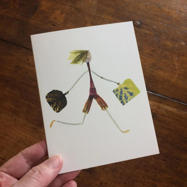 The BON VOYAGE CARD by PETAL PEOPLE PRESS features a charming stick figure illustration crafted from plant materials. The whimsical character strides briskly with leaf arms and legs, holding two larger leaves like bags against a plain white background. This card beautifully embodies the simplicity of botanical art, making it perfect for a pressed flower notecard.