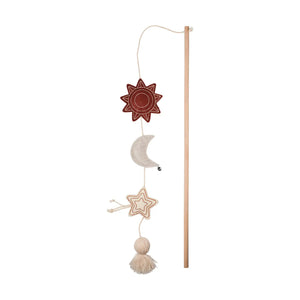 The PET SHOP BY FRINGE STUDIO's HAPPY SKIES CAT TEASER TOY features a wooden stick with a hanging toy: red star, silver crescent moon with bell, and beige star—linked by strings and ending in a tassel for interactive play to engage your cat.